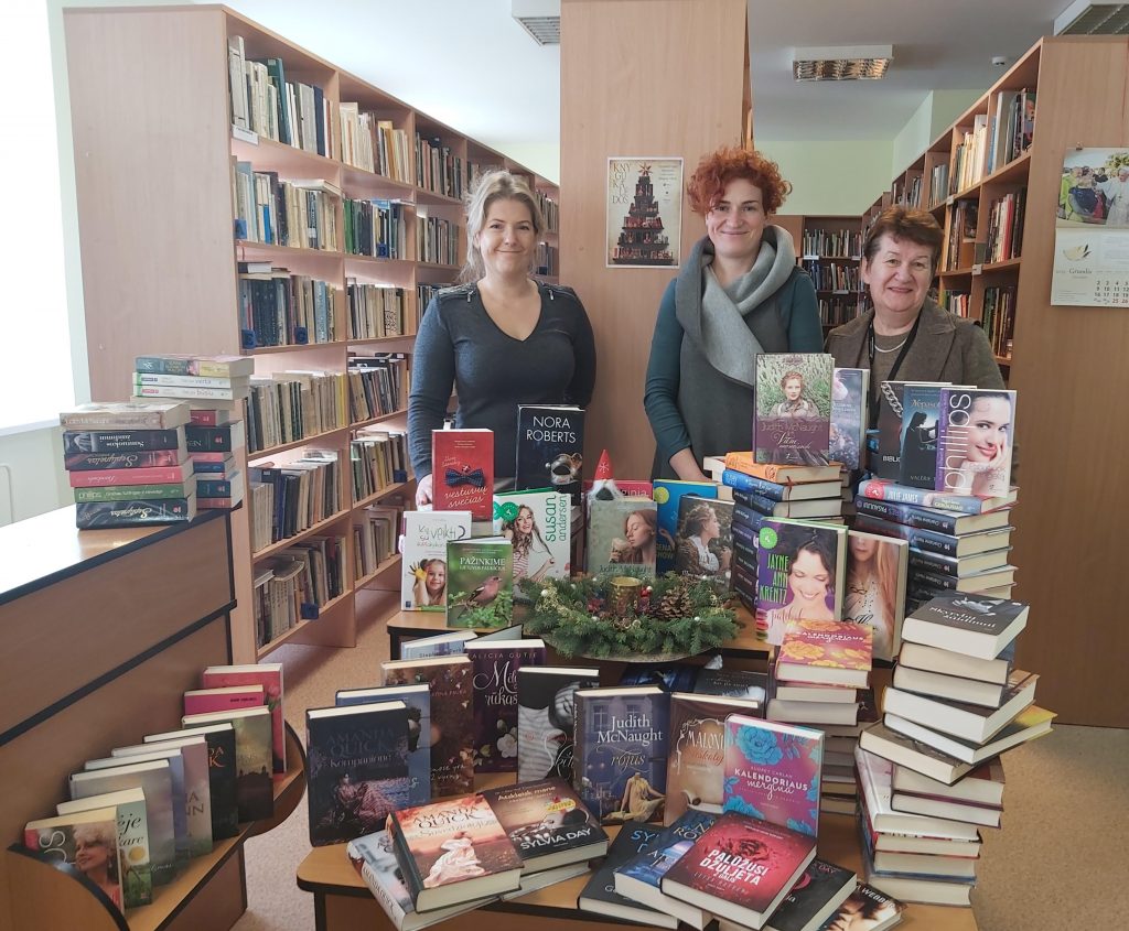 Prie bibliotekai dovanotų knygų stirtos išsirikiavo bibliotekininkė Milda Rogačiovienė (kairėje), vyresnioji bibliotekininkė Romutė Girskienė (dešinėje) ir knygas dovanojusi vydmantiškė Viktorija Viršilienė (viduryje).