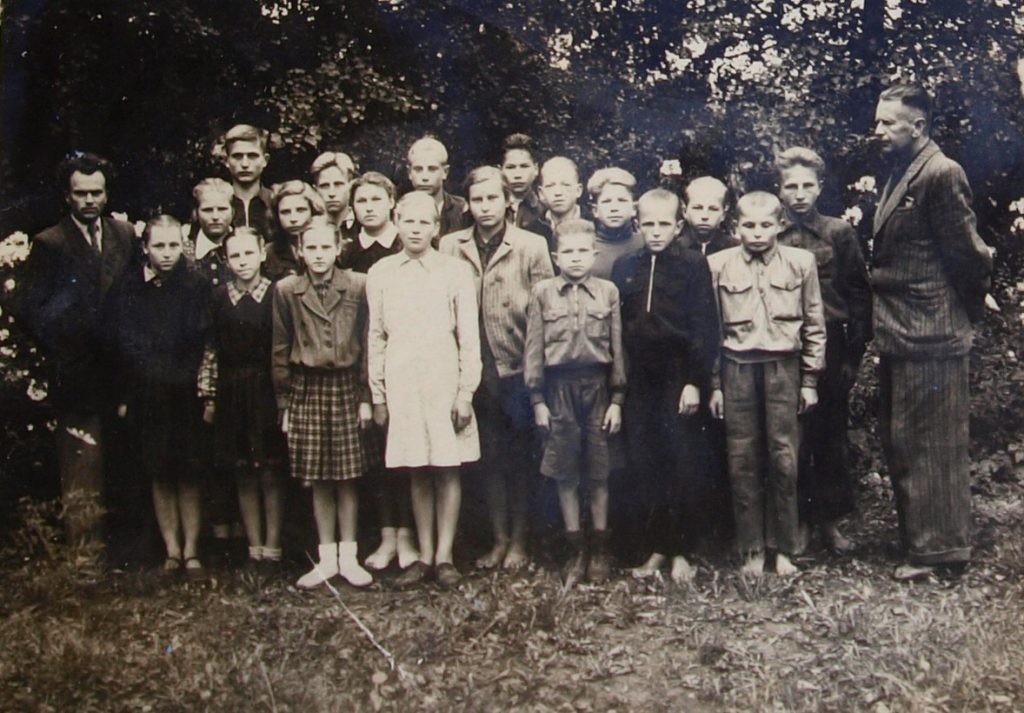 1953 m. Budriai. Ktetingos rajonas. Budrių septynmetės mokyklos septintokai. Pirmas iš dešinės mokyklos direktorius Vincas Jankauskas. Antras iš dešinės mokinukas (tamsiu treningu ir basas) - Stanislovas Lygutas. Stasiukas.